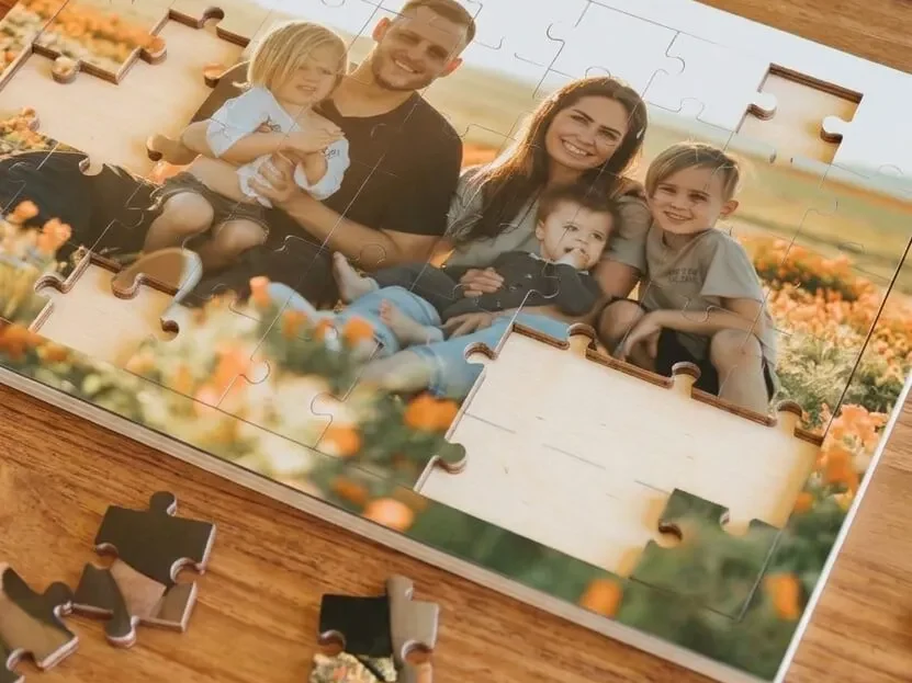 Houten fotopuzzel met een gezinsfoto op tafel, met losse stukjes ernaast
